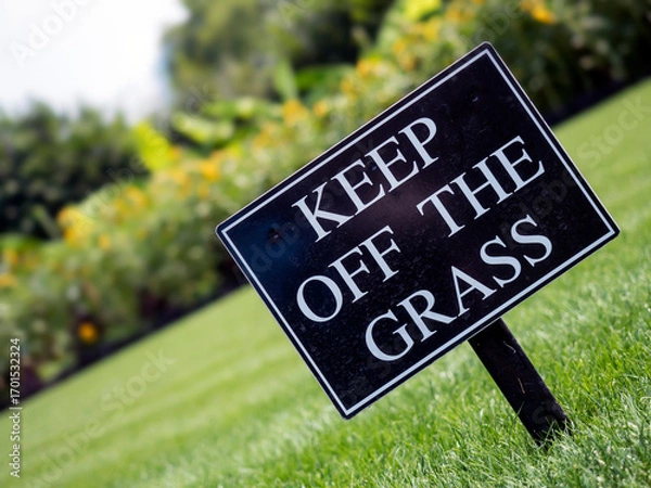 Fototapeta Keep Off the Grass sign on a nicely kept lawn in a park