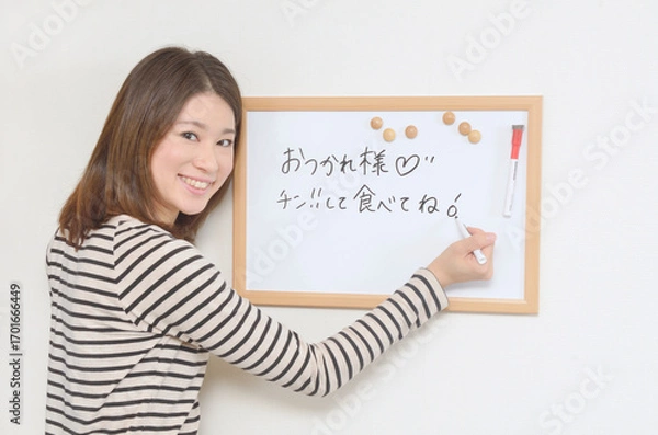 Fototapeta ホワイトボードにメッセージを書き込む若い女性	