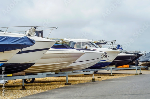Fototapeta Boat on stand on the shore, close up on the part of the yacht, luxury ship, maintenance and parking place boat