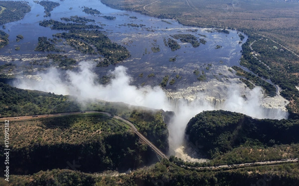 Fototapeta An aerial view of the Zambezi in flood at the Victoria fall with the road and bridge between Zimbabwe and Zambia