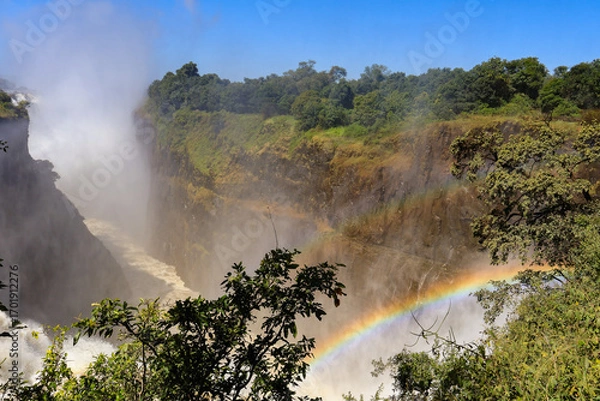 Obraz A view of the Victoria fall with the Zambezi river in flood creating lots of water spray and a rainbow
