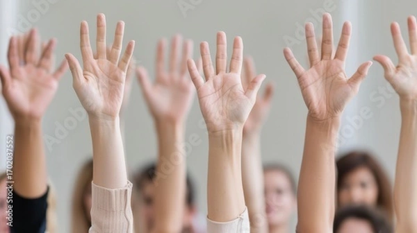 Fototapeta Raised hands of diverse people, symbolizing participation, voting, agreement, and engagement in a group setting.