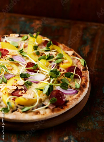 Fototapeta Pizza with chorizo ​​sausage, mozzarella cheese and yellow pepper. Rustic wooden background. Soft focus.	