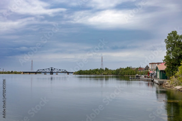 Obraz Tranquil waterfront scene at Little Current, Manitoulin Island, featuring the historic swing bridge against a serene sky and calm waters.