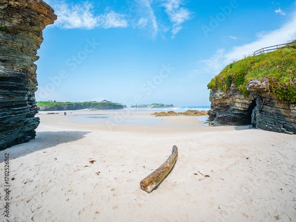 Fototapeta Playa des Catedrales in Galicia Spain sandstone rocks tidal pools sky cliffs wide shore under bright light clear blue sky peaceful calm natural wonder