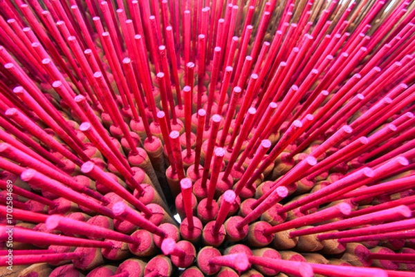 Fototapeta Bright pink incense sticks dry under the sun in Xianxi, Changhua, Taiwan. Traditional handmade incense creates a colorful display against a rustic backdrop.
