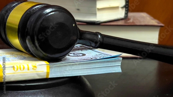 Fototapeta There is a wad of money on the table next to the judge's gavel.