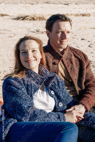 Obraz Portrait loving couple walks on beach along sea on sunny autumn day. Weekend and lifestyle concept. Vertical photo. High quality photo