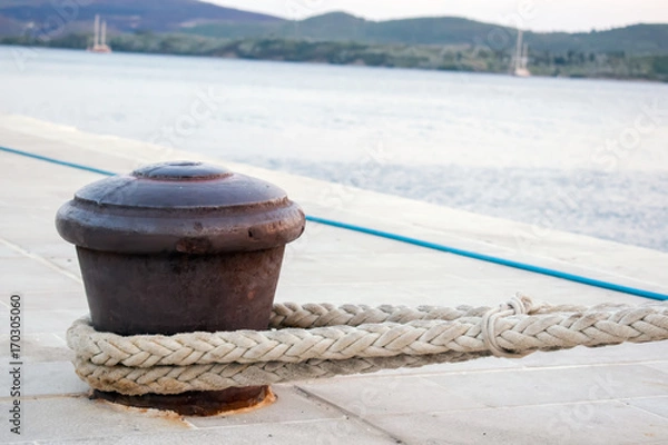 Fototapeta Rusty Boat Mooring on a Harbour Wall with Rope Attached