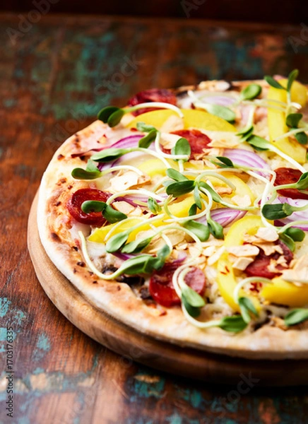 Fototapeta Pizza with chorizo ​​sausage, mozzarella cheese and yellow pepper. Rustic wooden background. Soft focus.	