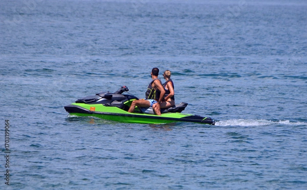 Fototapeta Couple Riding Tandem on a Jetski