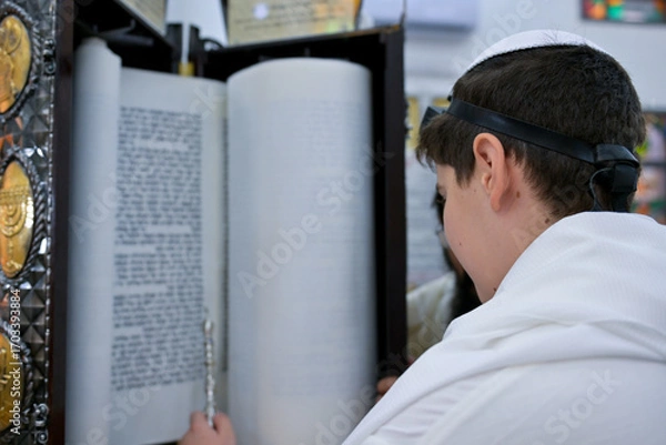 Obraz A bar mitzvah boy reading from the Torah scroll in a synagogue.