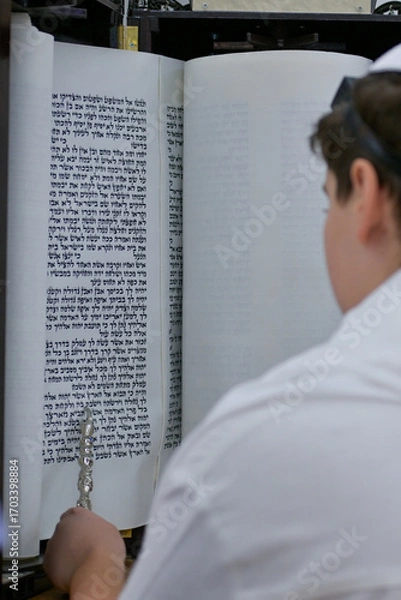 Obraz A bar mitzvah boy reading from the Torah scroll in a synagogue.
