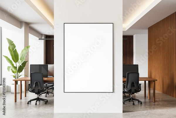 Fototapeta Modern office interior with blank poster mockup on white wall in front of wood-accented workspace and ergonomic chairs. 3D Rendering