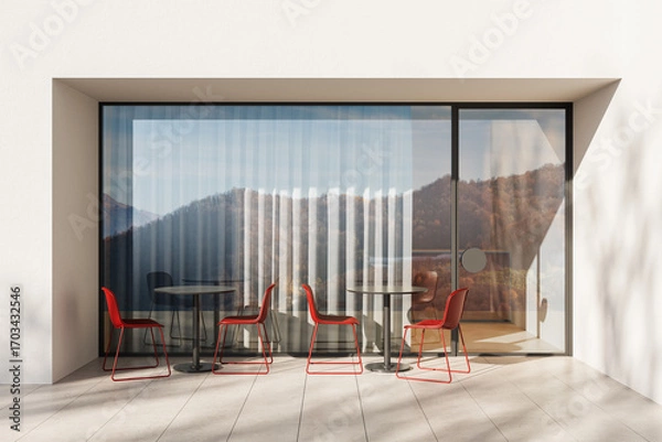 Fototapeta Minimalist outdoor cafe area with red chairs and round tables against a modern glass wall reflecting mountains and sky, architectural daylight scene. 3D Rendering