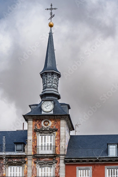 Fototapeta Ornate clock tower with slate spire and golden sphere finial, part of Casa de la Panaderia in Plaza Mayor, Madrid, Spain