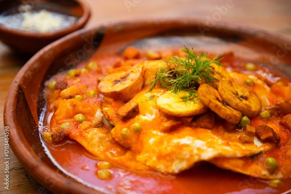 Obraz Huevos Motuleños are a Mexican breakfast, typical of the city of Motul, Yucatán. The dish is based on a fried tortilla with refried black beans and a fried egg on top.