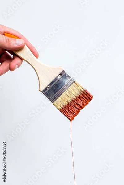 Fototapeta Wooden handle brush with dripping red paint isolated over white background