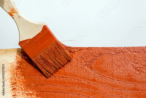 Fototapeta A paintbrush on a wooden surface in close-up on a white background.
