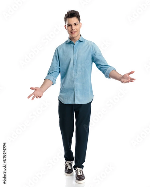 Fototapeta excited young man in denim shirt opening arms and inviting