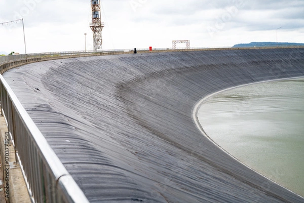 Fototapeta HDPE plastic lined water reservoirs and landscape of wind farm for power generating stations. High density polyethylene engineering material. Wind power. Sustainable, renewable energy. Windmill farm.