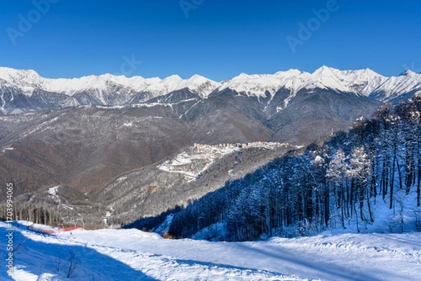 Fototapeta A beautiful winter landscape with a mountain resort and snow on the slopes.