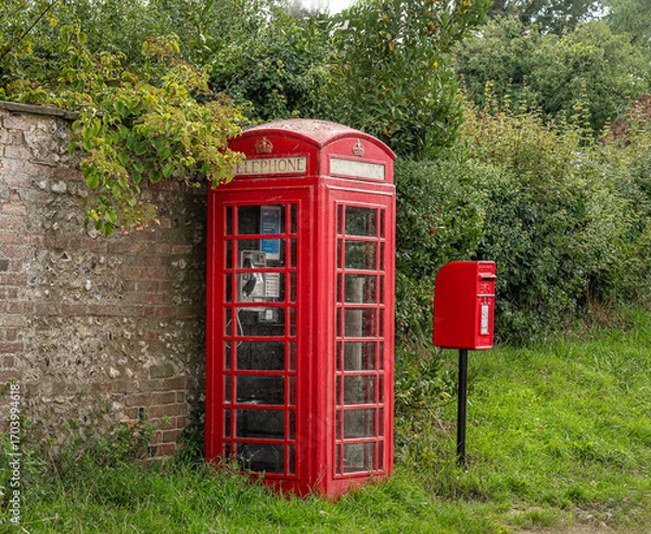 Fototapeta red telephone box complete with phone beside a red post box