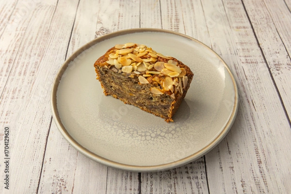 Fototapeta Carrot sponge cake with walnut pieces and raisins, sprinkled with cinnamon and topped with a smooth cream cheese frosting and rustic decoration