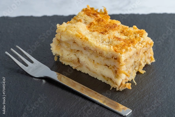 Fototapeta Moist layered apple semolina pie with crispy golden topping and fork.
