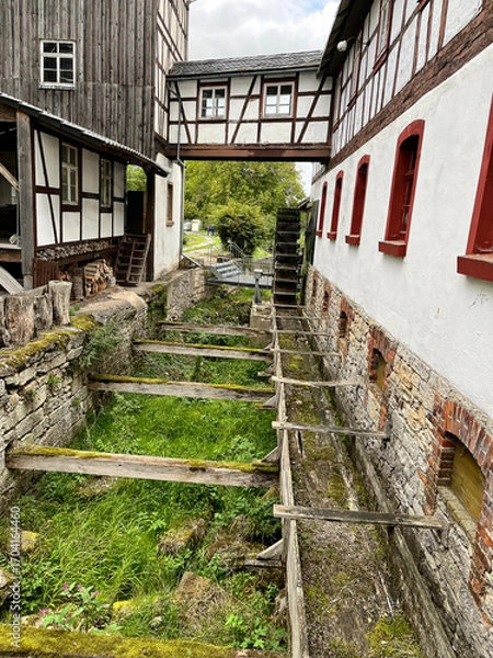 Obraz Detailansicht einer historischen Mühle mit Zulauf und Mühlrad