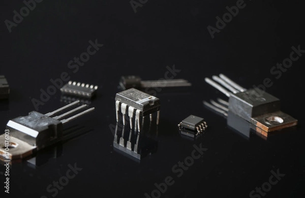 Fototapeta Semiconductor electronic circuit components on a black. Focused on 8-pin integrated circuits.