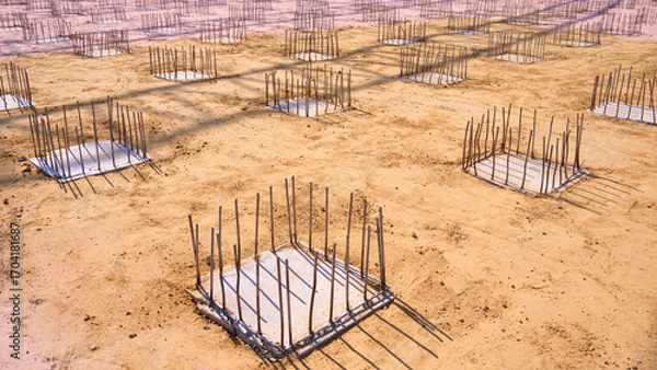Fototapeta Deep foundation footing reinforcement steel on the ground for reinforced concrete flooring work in industrial factory building construction site area