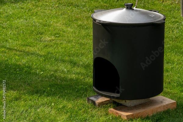 Fototapeta Тhe firebox for the cauldron stands on boards in the grass
