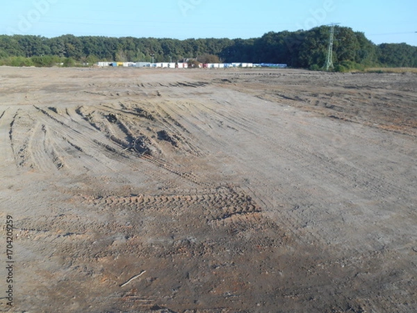 Obraz Flat terrain, newly leveled. Trees in the background.