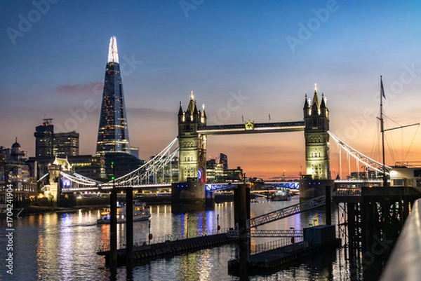 Fototapeta Tower Bridge illuminated in the early evening with a stunning pink sunset in background
