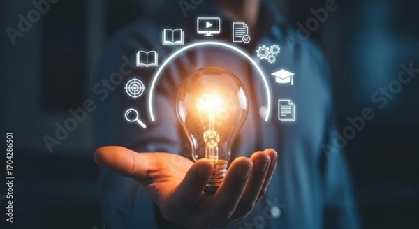 Fototapeta Person holding a glowing light bulb with educational icons in a semicircle above