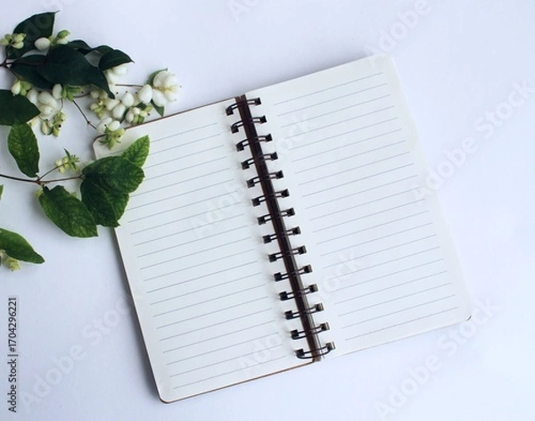 Fototapeta Blank notebook and jasmine flowers on a white background.