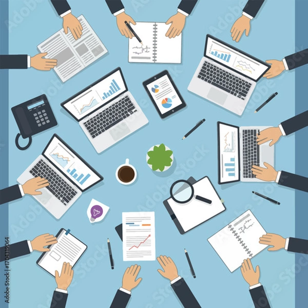 Fototapeta Overhead view of a business meeting with laptops and financial documents