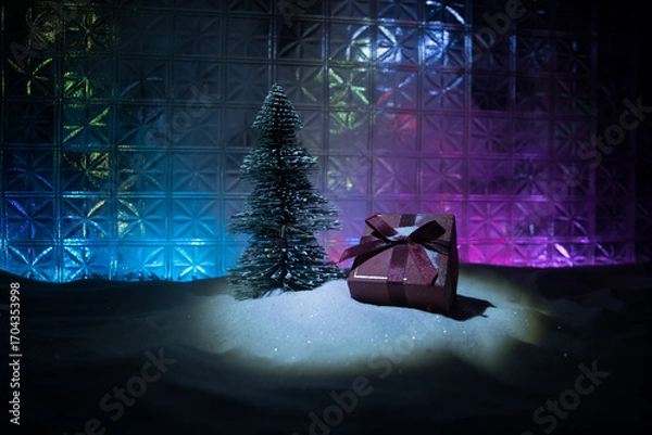 Fototapeta Christmas home decoration with snow and tree on a dark background with copy space. Selective focus. New Year attributes on background