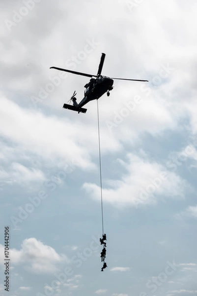 Fototapeta Soldiers of the special intervention unit of the armed forces attached to a rope from a helicopter