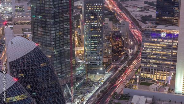 Fototapeta Skyline of the buildings of Sheikh Zayed Road and DIFC aerial day to night timelapse in Dubai, UAE.