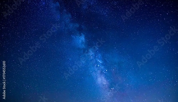 Fototapeta Vast, deep blue night sky showcasing a luminous band of stars and cosmic dust, resembling a flowing river