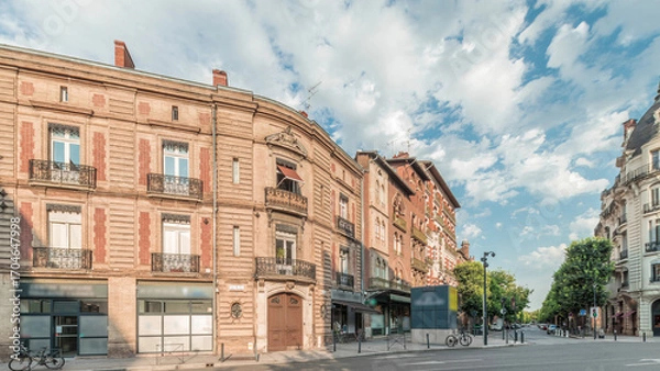 Fototapeta Panorama showing historic brick facades at Rue du Languedoc and Theodore Ozenne intersection timelapse in Toulouse, France.
