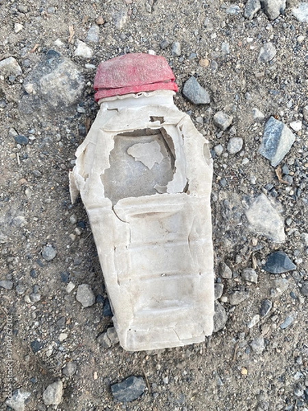 Fototapeta plastic bottle with water and garbage on the ground