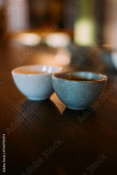 Fototapeta Sake cup. Serving alcoholic drink. Pair of little empty clay bowls for traditional asian beverage. Ceramic for rice wine on bar table.