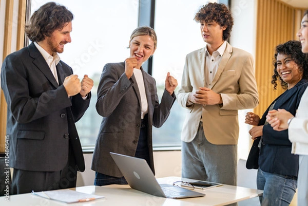 Fototapeta Business team celebrating success with raising fist in office, joyful expression teamwork spirit, multicultural collaboration, group achievement, workplace motivation, inclusive company