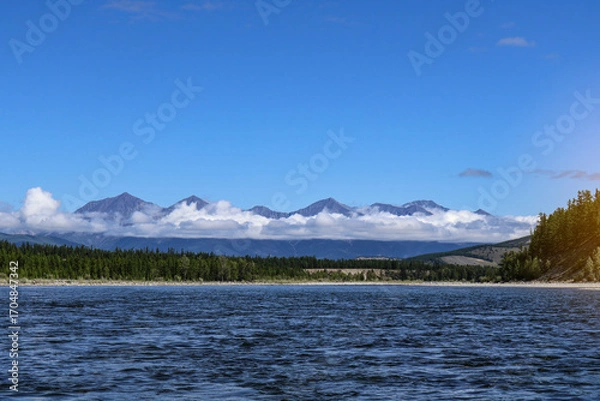 Fototapeta Mountain ridge with clouds covering the middle, peaks and base visible