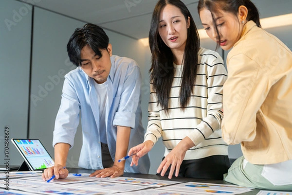 Fototapeta Group of asian business meeting and discussing strategy startup project analysis finance process.Success business people work plan and brainstorm marketing idea in office.Teamwork