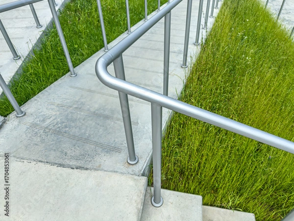 Fototapeta ramp with metal safety handrails for disabled persons in wheelchairs. helpful structure. closeup view.