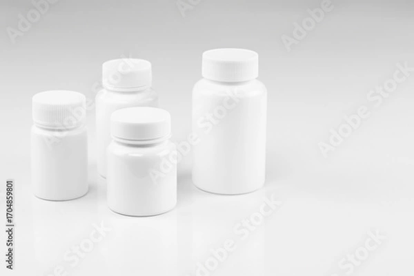 Fototapeta Set of four blank white pill bottles, isolated on white background.